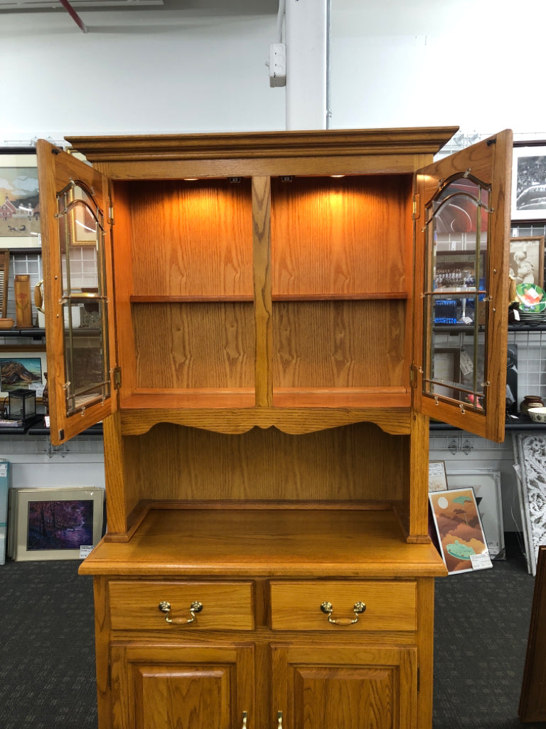 2PC OAK HUTCH W/GLASS DOORS AND LIGHTS BRASS HANDLES.