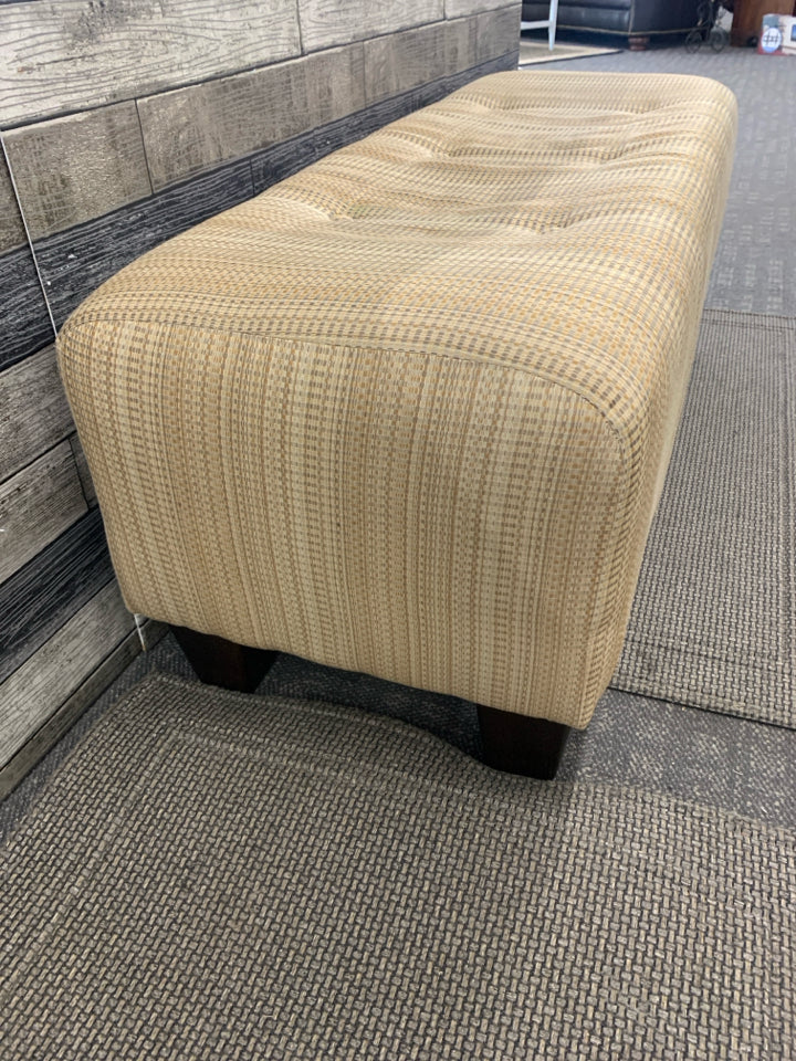 TAN OTTOMAN BENCH, SILK WEAVE TEXTURE W/BUTTON DETAIL.