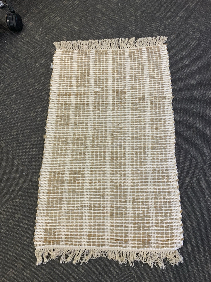 BROWN AND WHITE TASSEL AREA RUG.