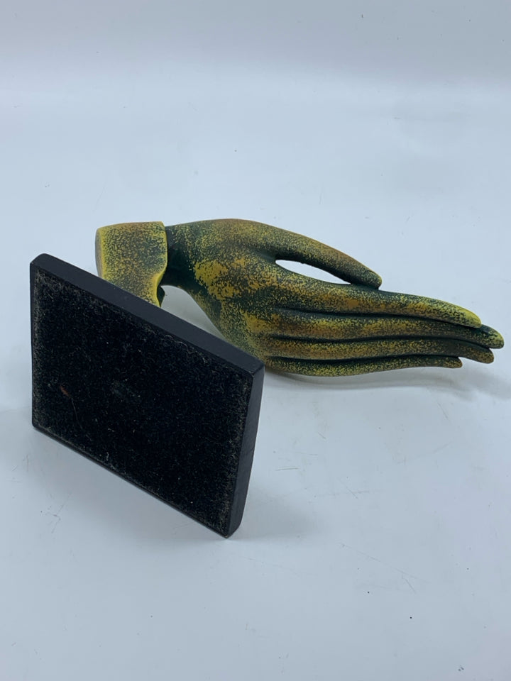 DISTRESSED GREEN AND GOLD HAND SCULPTURE ON BLACK BASE.
