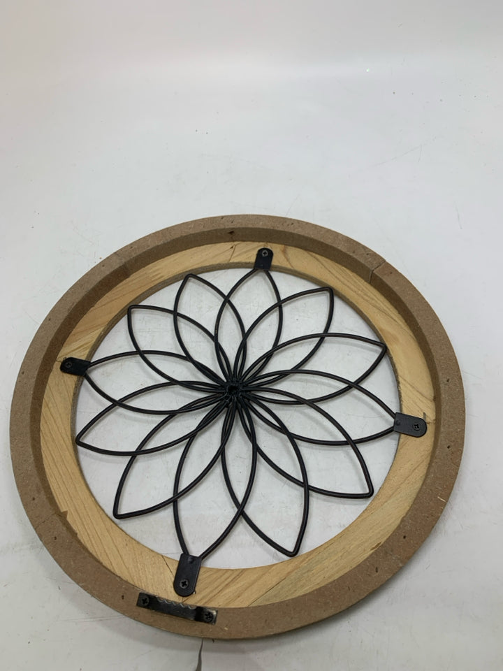 CIRCLE FRAME W/ METAL FLOWER IN CENTER.