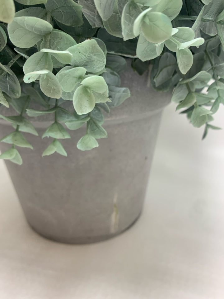 FAUX GREENERY BUSH IN GREY PLASTIC POT.