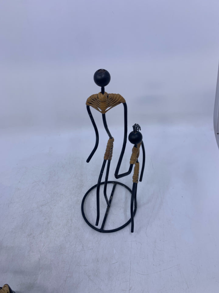 BLACK METAL 2 PEOPLE HOLDING HANDS W/ 1 LEG UP FOLK ART.