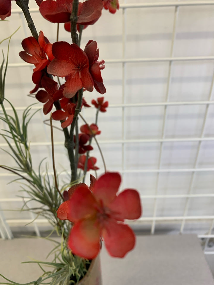 FAUX RED FLORALS IN POCKET VASE ON METAL STAND.