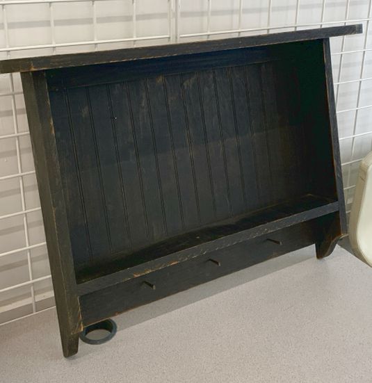 DISTRESSED BLACK WALL SHELF W/ PEG HOOKS.