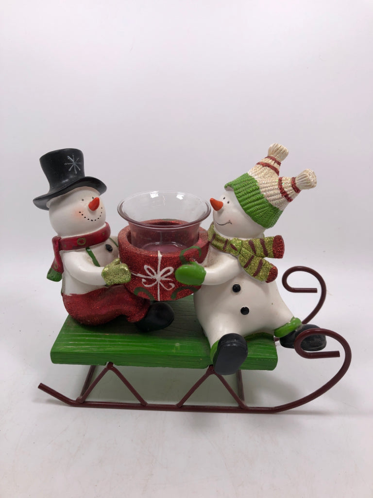 SNOWMEN ON SLEIGH HOLDING VOTIVE HOLDER.