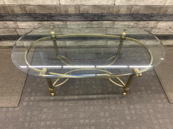 GOLD FOOTED GLASS TOP OVAL COFFE TABLE.