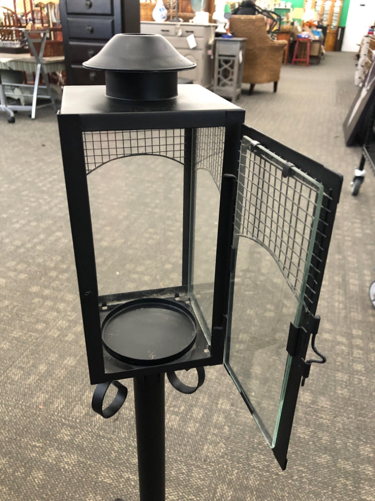BLACK METAL SCROLL BASE CANDLE LANTERN.