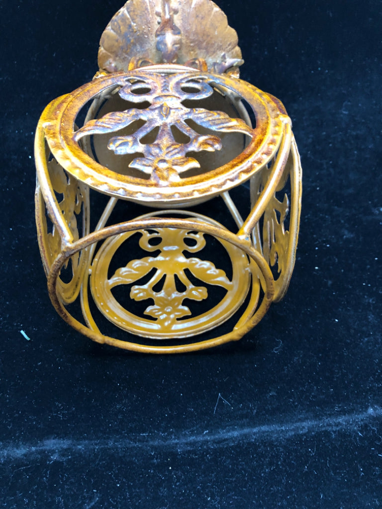 RUST COLORED METAL ORNATE PILLAR CANDLE HOLDER.