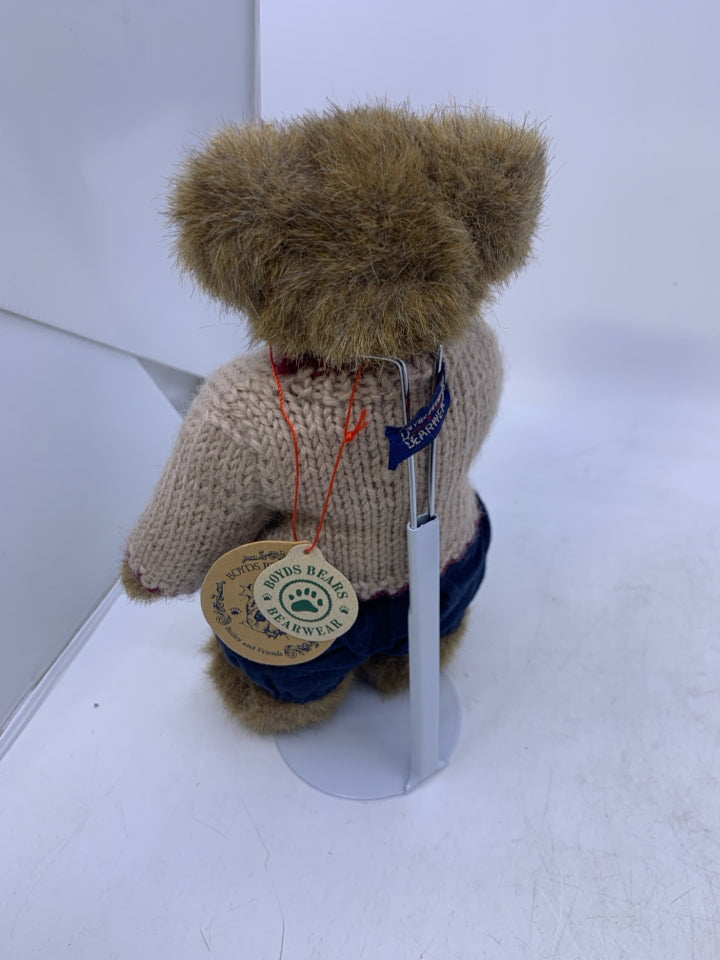 LIGHT BROWN BEAR W/ BEIGE SWEATER BLUE PANTS ON STAND.