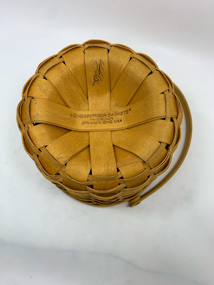 1999 ROUND BASKET W/ PLASTIC INSERT AND WOOD COVER AND HANDLE.