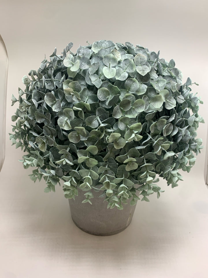 FAUX GREENERY BUSH IN GREY PLASTIC POT.
