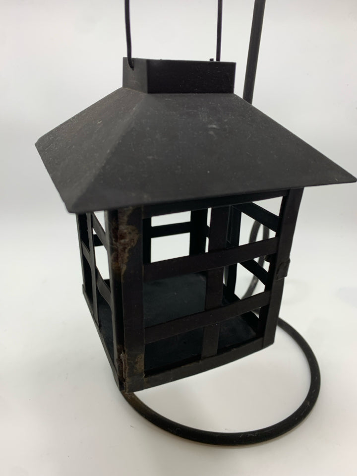BLACK METAL LANTERN ON SCROLL STAND.