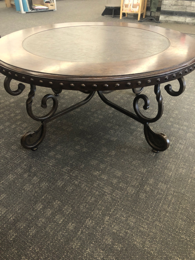 ORNATE BROWN COFFEE TABLE W/CENTER DESIGN & METAL ACCENTS.