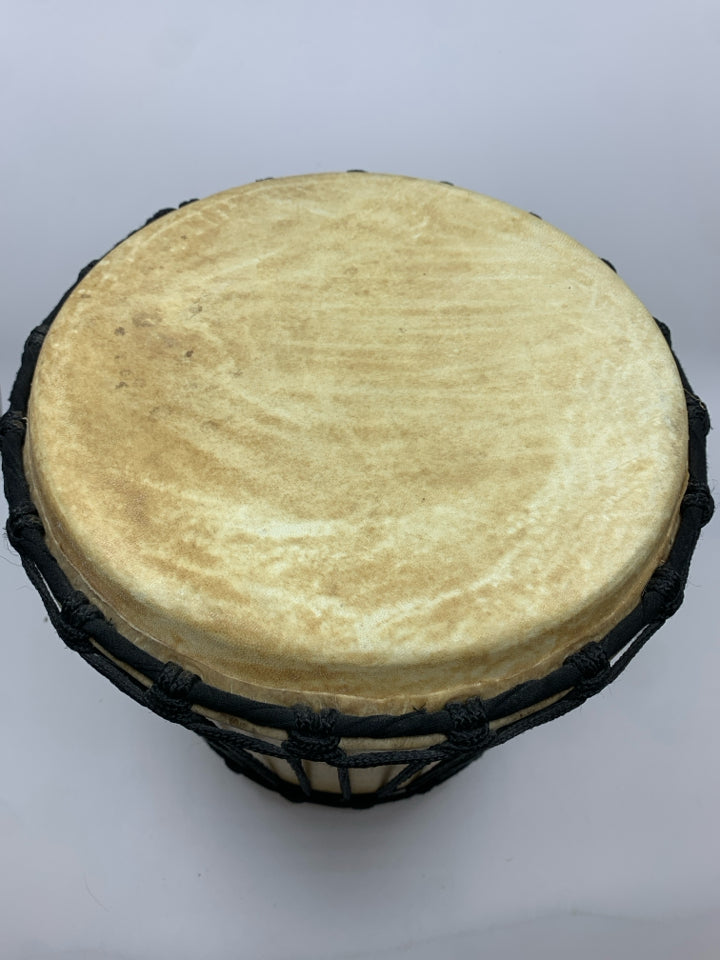 LIGHT COLORED DRUM W/BLACK ROPE.