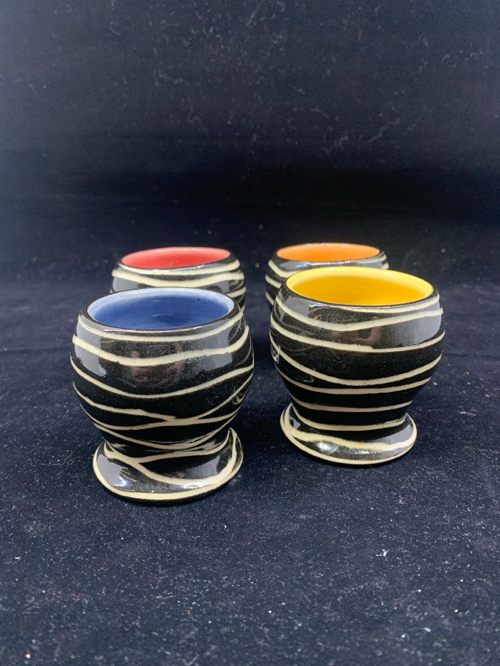 4 COLORFUL BLACK AND WHITE EGG CUPS.