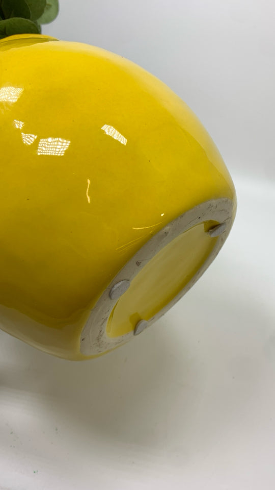 FAUX EUCALYPTUS IN YELLOW CERAMIC PITCHER.