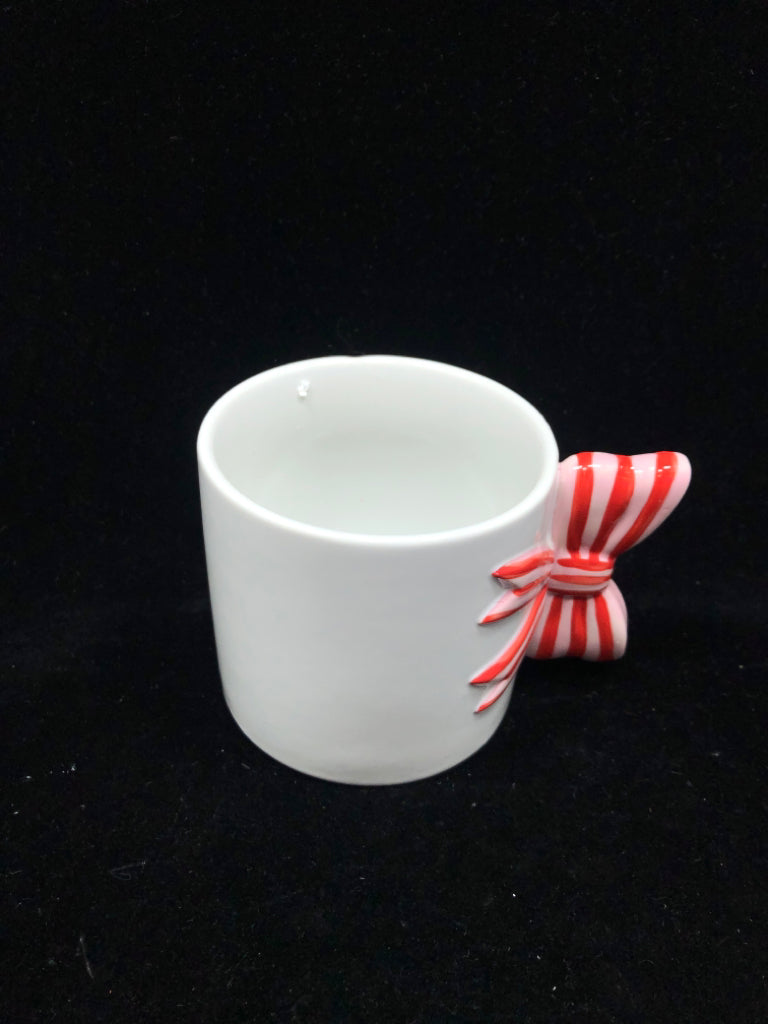 WHITE MUG W/ PINK/RED BOW HANDLE.