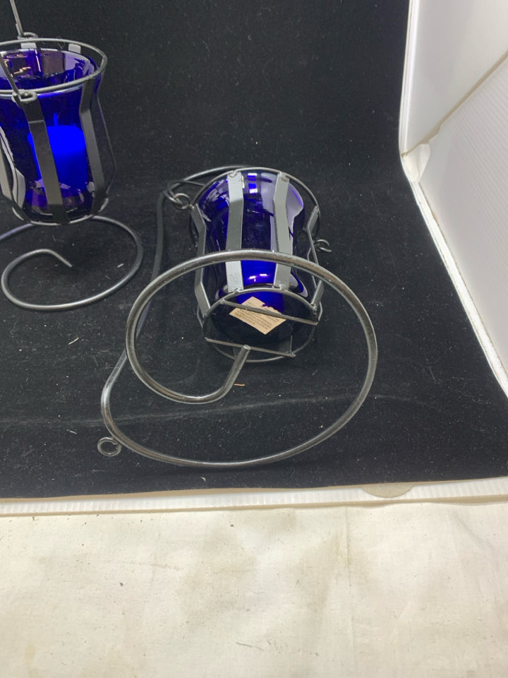 2 HANGING BLUE GLASS CANDLE HOLDERS.