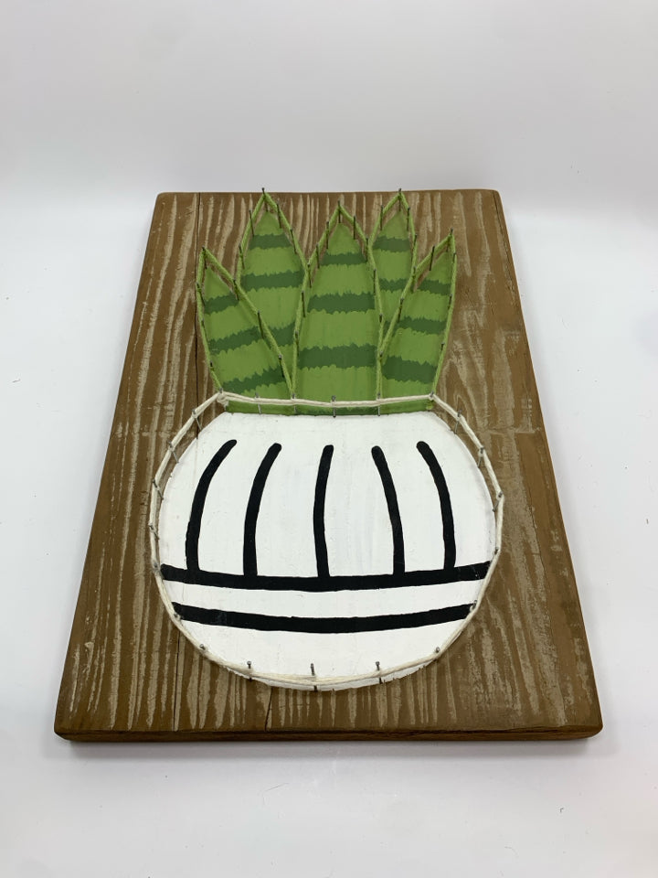 STRING ART SNAKE PLANT ON RUSTIC WOOD BLOCK.