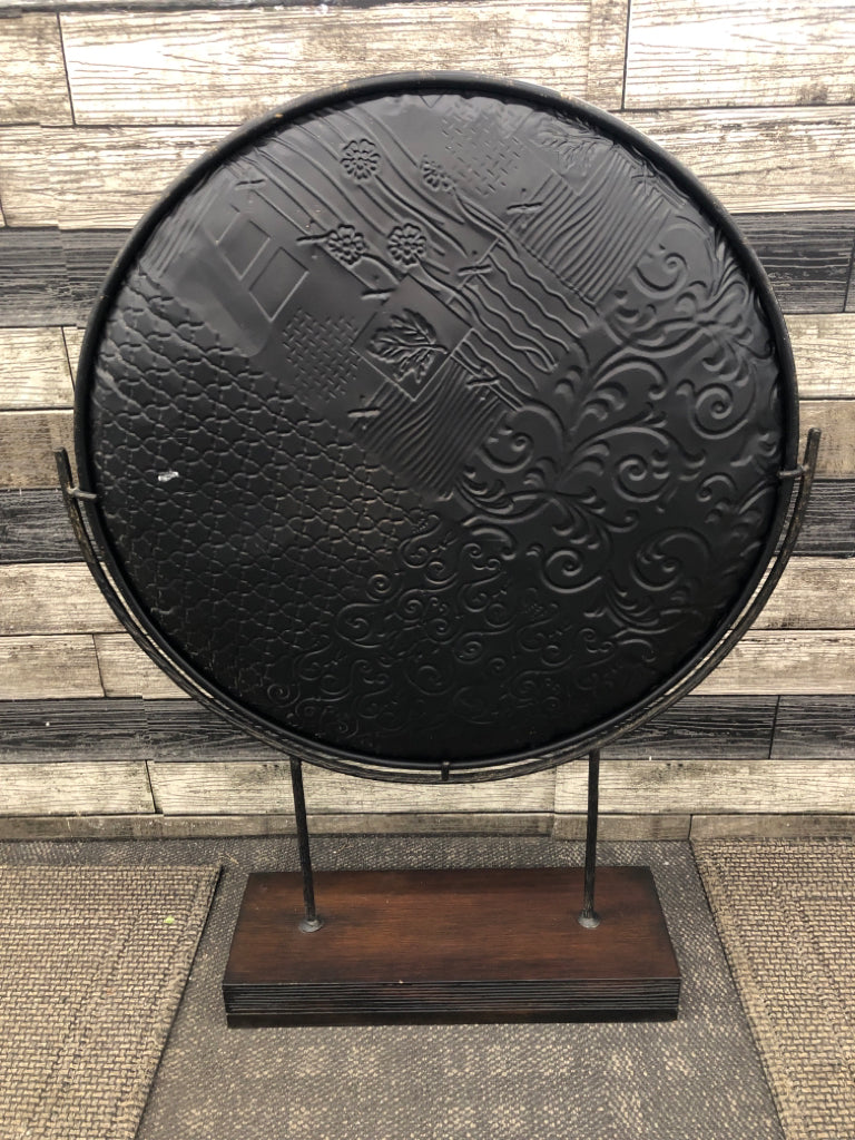 LEAF EMBOSSED ROUND METAL CENTERPIECE ON WOOD STAND.
