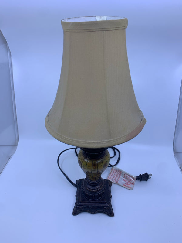 SMALL BROWN SCROLL BASE LAMP WITH TAN SHADE.