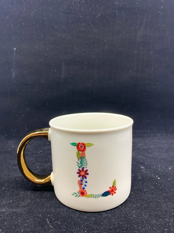 WHITE MUG W/ FLORAL "L" GOLD HANDLE.