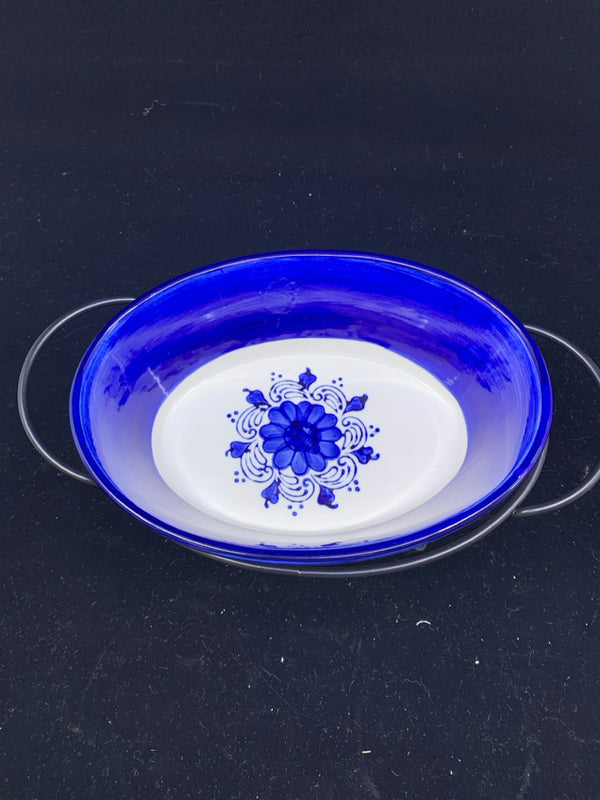 BLUE AND WHITE OVAL DISH IN BLACK METAL STAND.