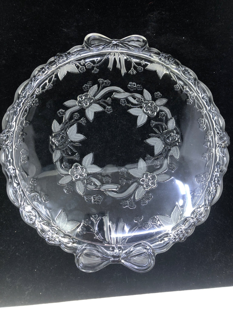CLEAR GLASS CAKE PLATE W/ ETCHED FLOWERS/EMBOSSED BOW HANDLES.