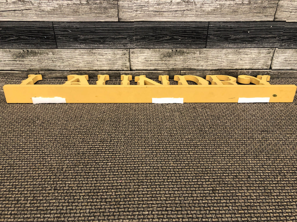 DISTRESSED YELLOW LAUNDRY SIGN.
