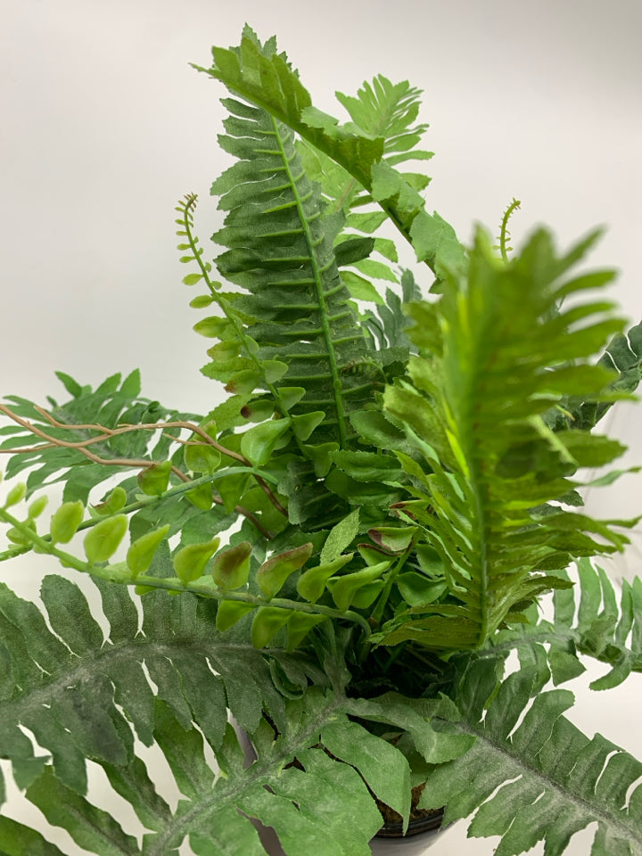FAUX FERN IN BROWN CERAMIC POT.