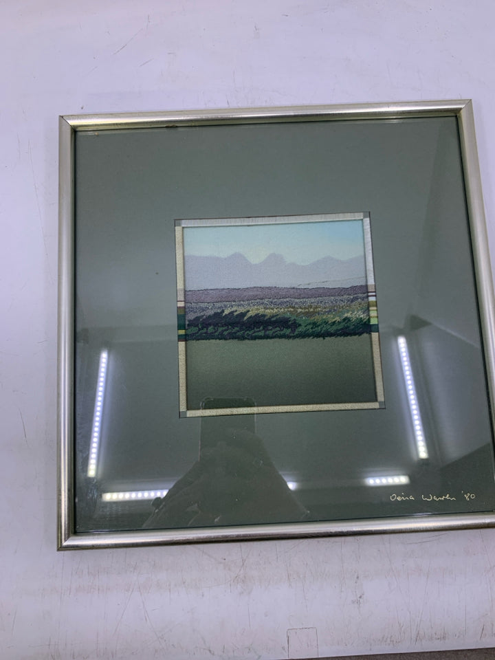 YARN EMBROIDERED GREENS LANDSCAPE IN SILVER FRAME.