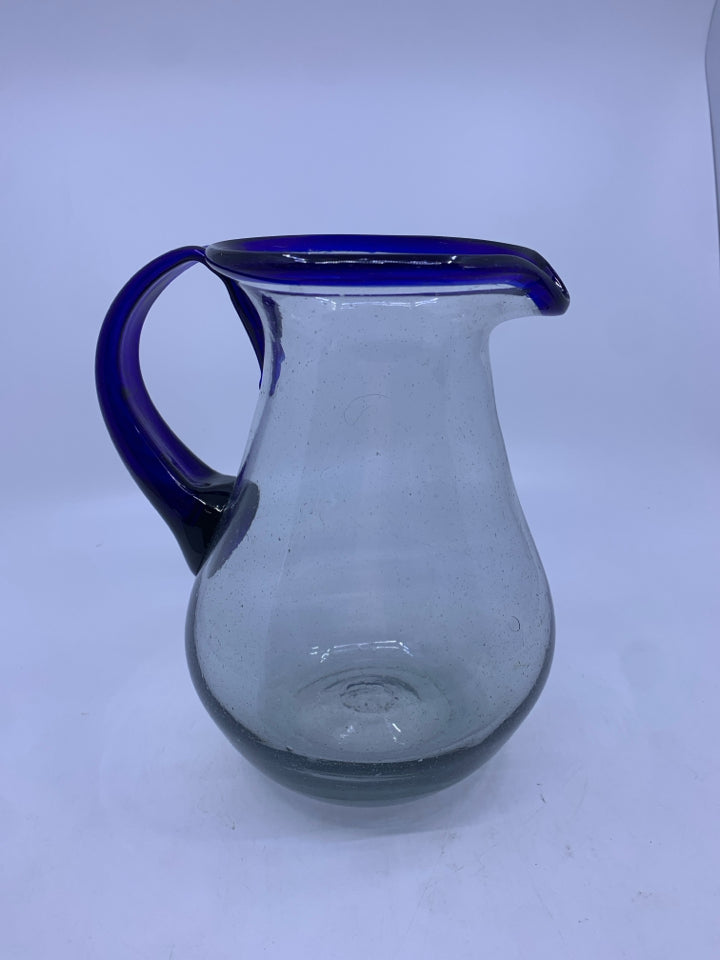 CLEAR GLASS PICTURE W/BLUE HANDLE AND RIM.