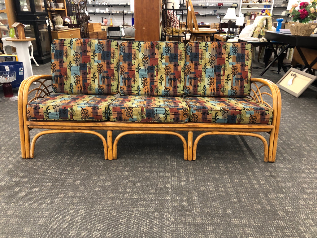 RATTAN SOFA W/PATTERNED FABRIC.