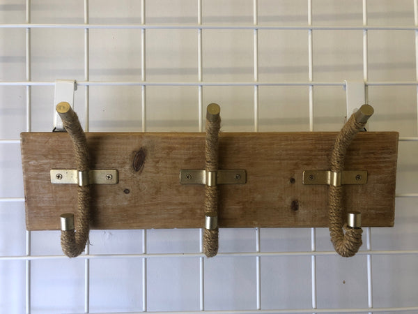3 ROPE HOOKS ON WOOD WALL HANGING.