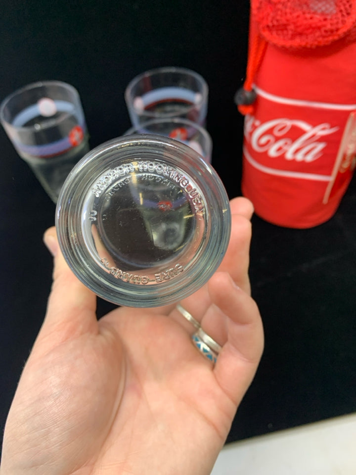 4 COCA-COLA THEMED STACKABLE GLASSES IN CARRYING SLEEVE.