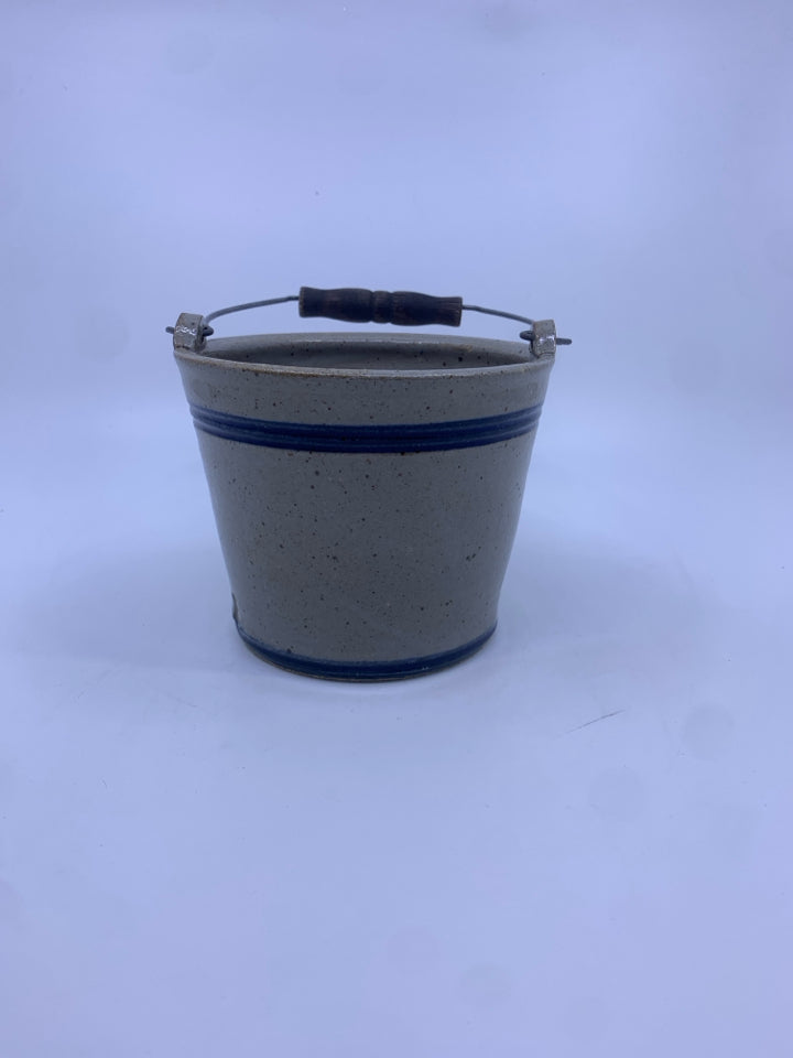 POTTERY W/BLUE AND METAL HANDLE.