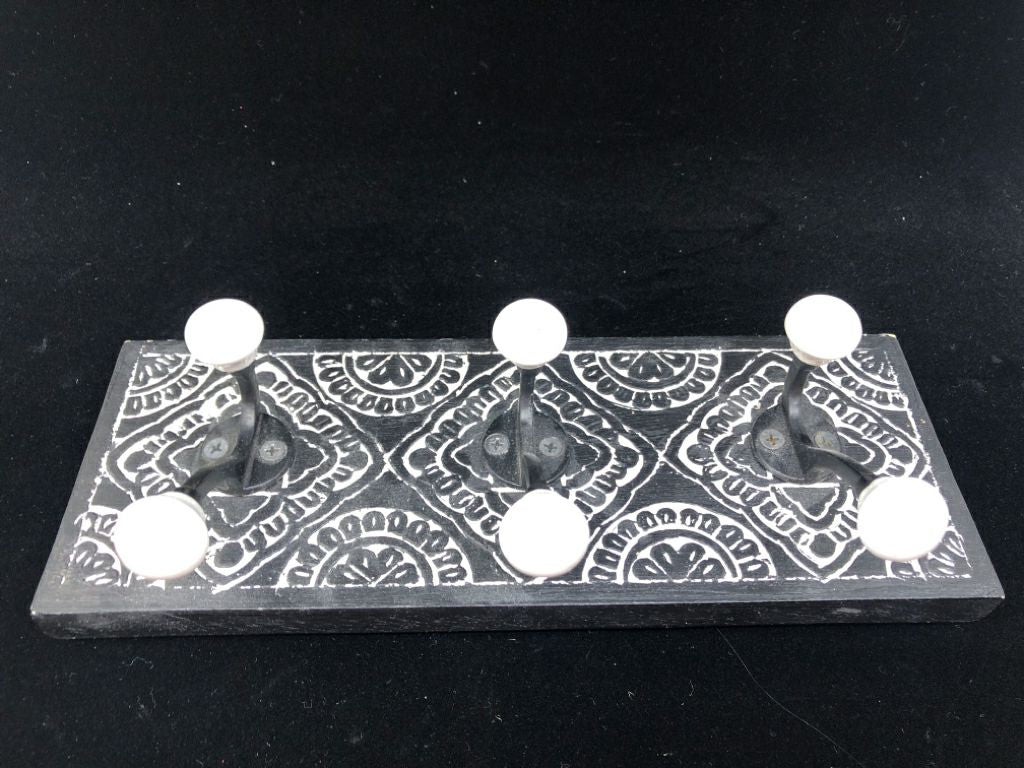 BLACK 3 HOOK  WALL ART W/ CARVED WHITE DETAILS.
