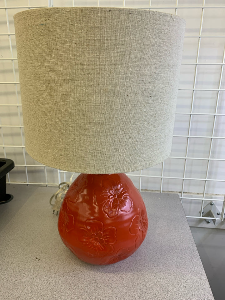 RED CERAMIC BASE W/ EMBOSSED FLOWERS TEXTURED SHADE.