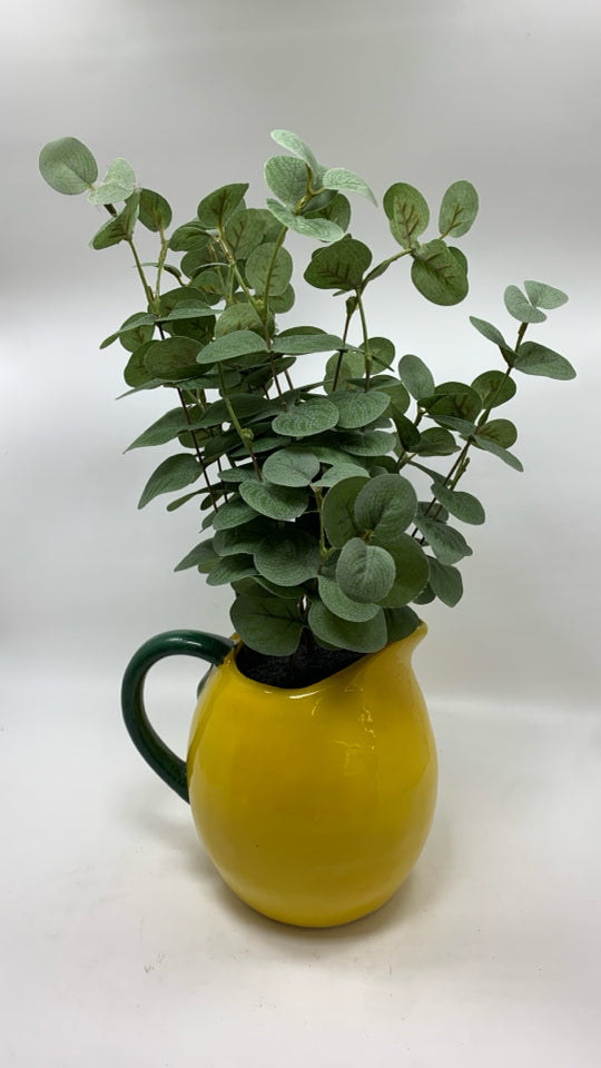 FAUX EUCALYPTUS IN YELLOW CERAMIC PITCHER.