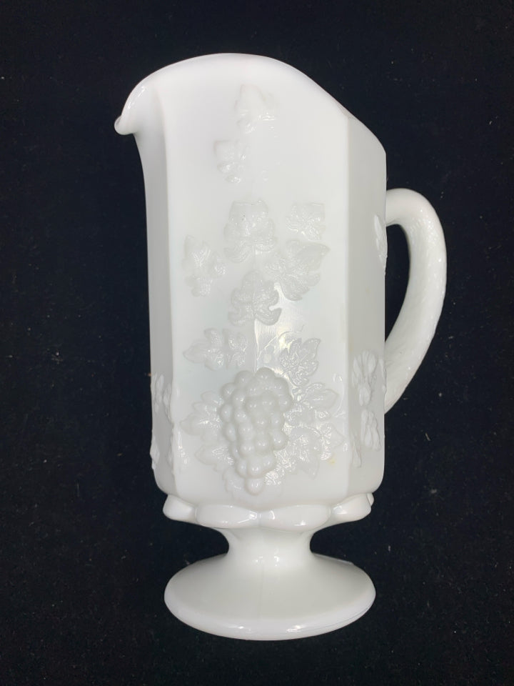 VTG MILK GLASS FOOTED PITCHER W/ EMBOSSED GRAPES + VINES.