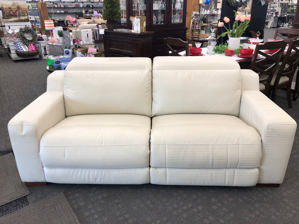 WHITE FAUX LEATHER RECLINING LOVE SEAT.