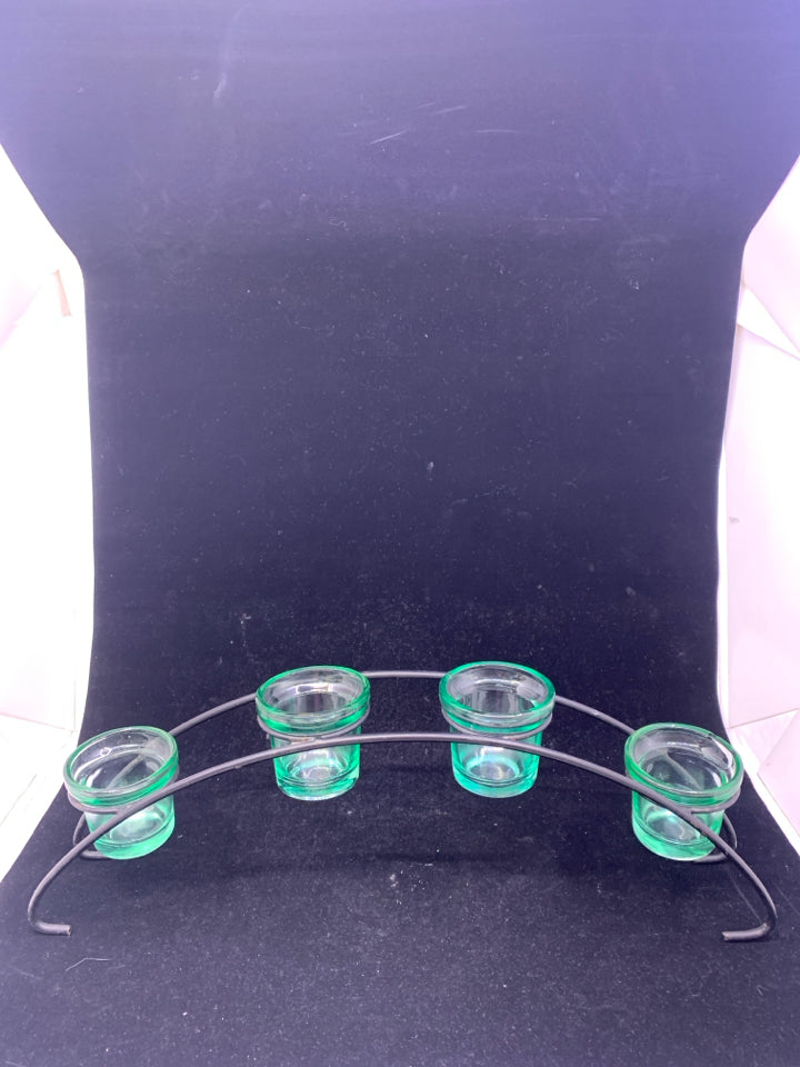 4 GREEN GLASS TEA LIGHT HOLDERS IN BLACK ARCHED STAND.