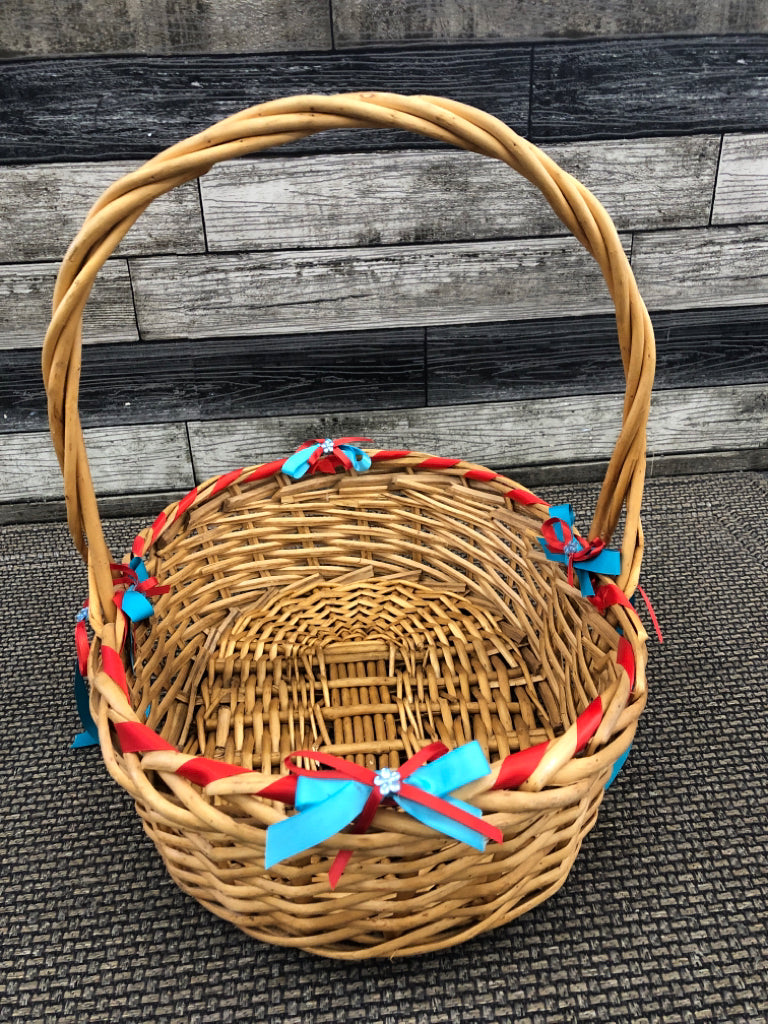 BLONDE WICKER BASKET W/BLUE AND RED BOWS.