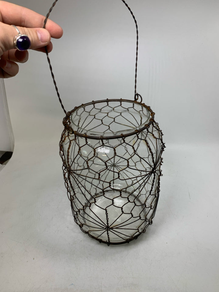 LARGE GLASS JUG W/ RUSTED METAL CAGE HANGING LANTERN.