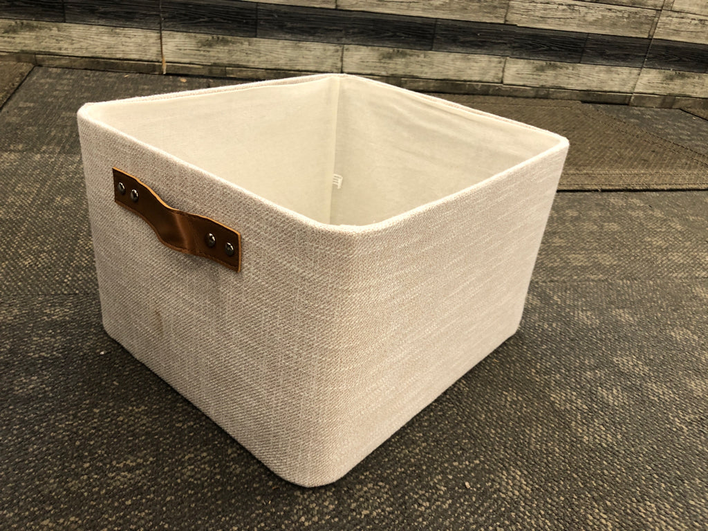 GREY FABRIC STORAGE BIN W/FAUX LEATHER HANDLES.