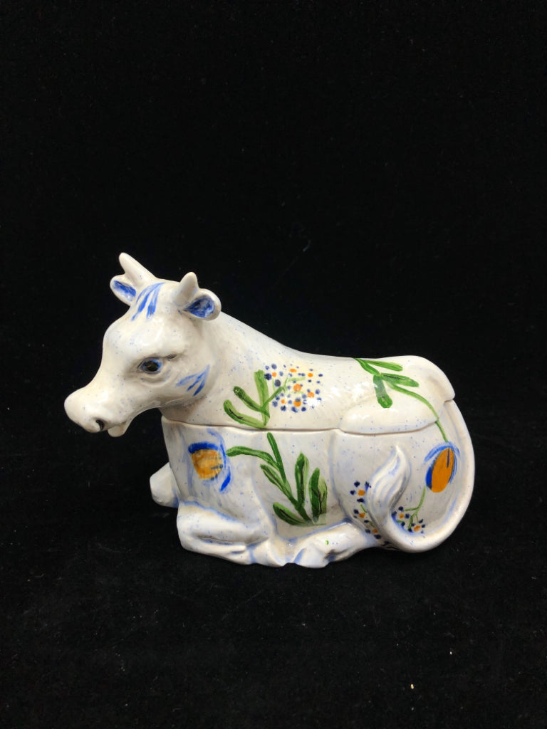 CERAMIC COW CANISTER W/BLUE & YELLOW FLORAL MOTIFS.