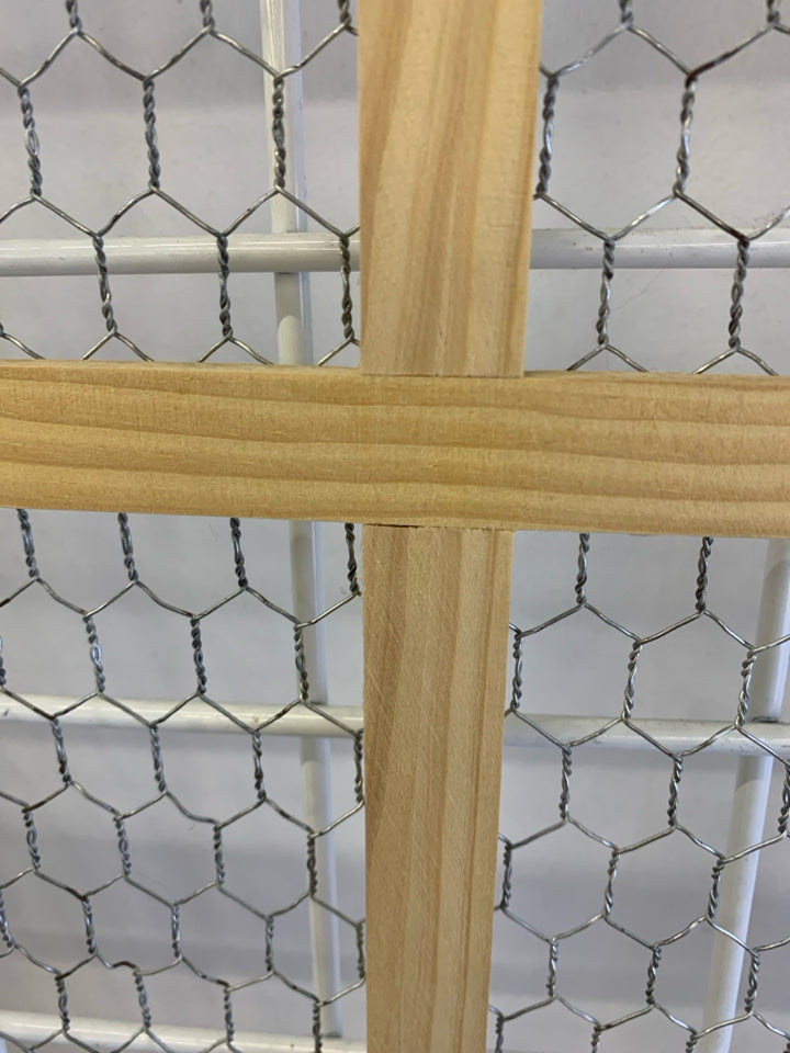 CHICKEN WIRE IN BLONDE WINDOW FRAME.