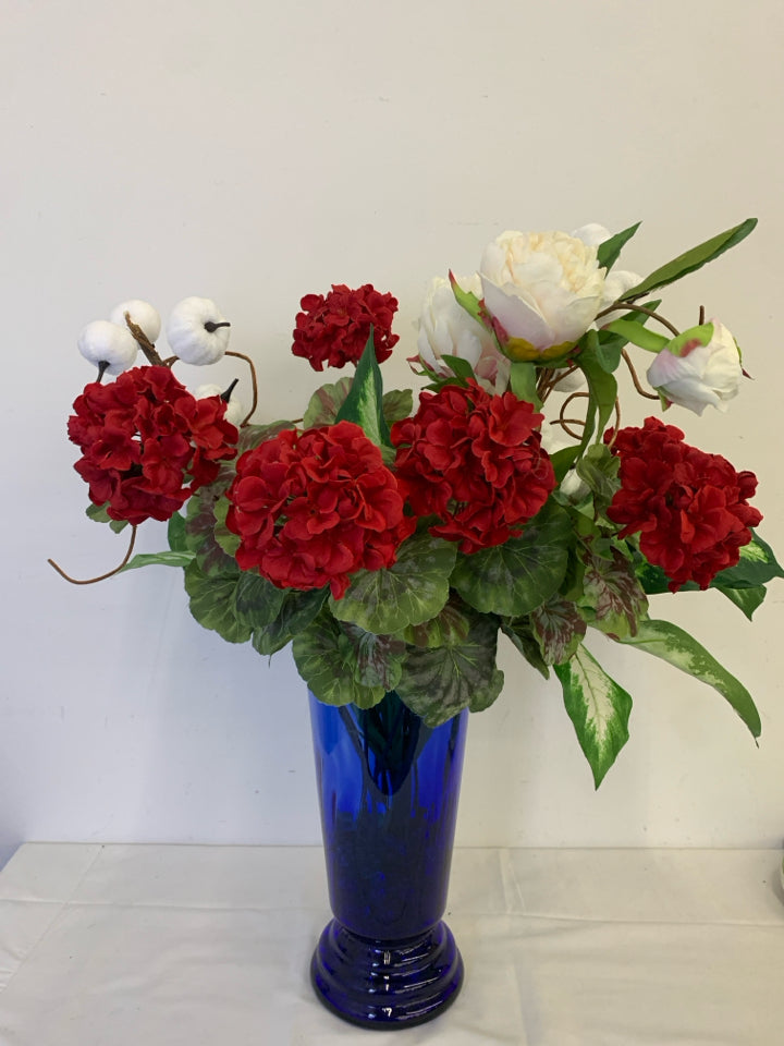 TALL BLUE VASE W PUMPKIN AND FAUX RED AND WHITE FLORAL.