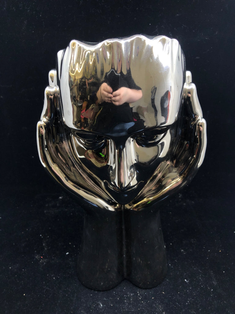 CERAMIC SILVER PERSON HOLDING UP THEIR FACE.